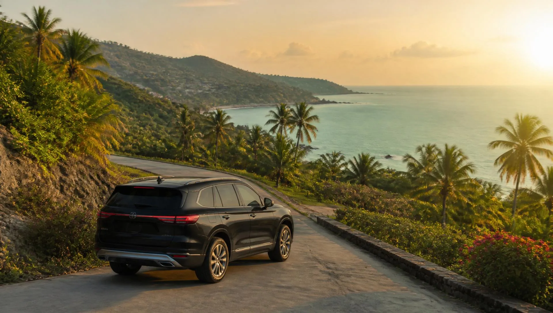 Black SUV on a winding tropical hillside road overlooking the sea at golden hour on Koh Samui